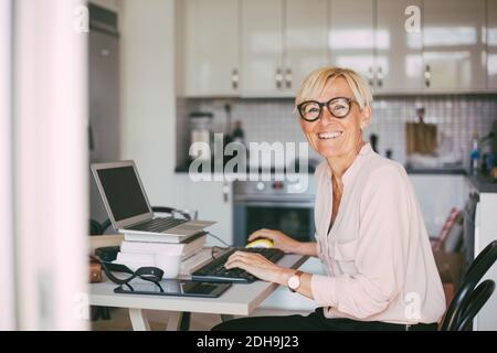 Portrait of happy woman working at home Stock Photo