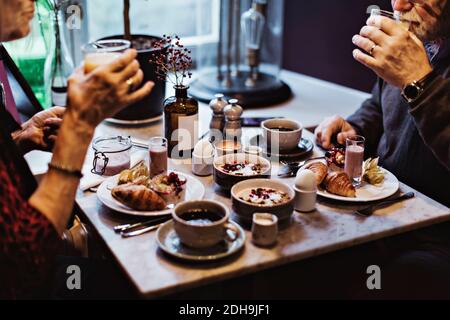 Midsection of senior couple having breakfast at table in hotel Stock Photo