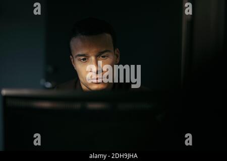 Close-up of businessman using computer in office at night Stock Photo