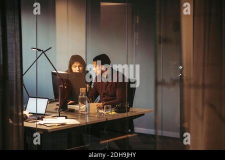 Business people discussing while working at desk in dark office Stock Photo