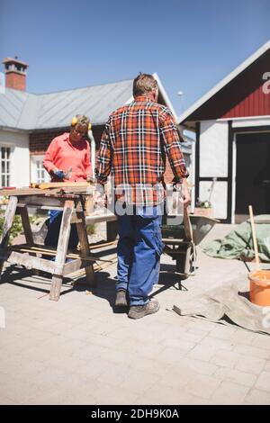 Senior couple doing carpentry at yard Stock Photo