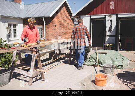 Senior couple doing carpentry at yard outside house Stock Photo