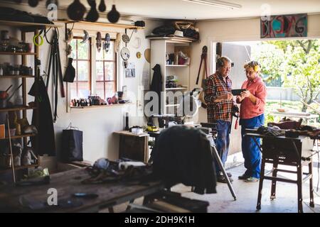 Full length of senior couple using digital tablet in workshop Stock Photo