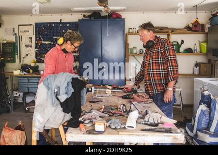 Senior couple standing at workbench in workshop Stock Photo