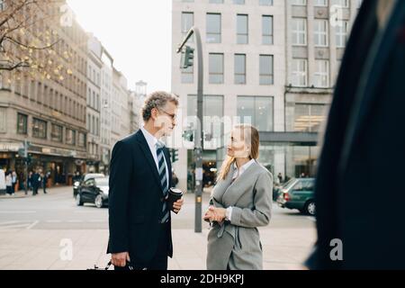 Business colleagues talking while standing in city Stock Photo