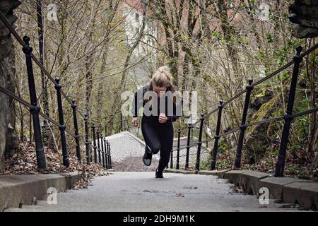 Full length of fit woman moving up stairs Stock Photo