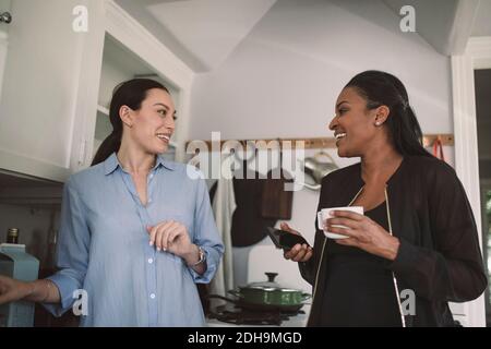 Smiling female design professionals discussing in kitchen at home office Stock Photo