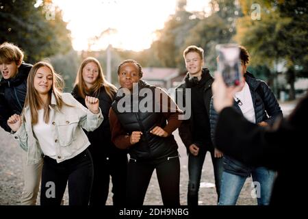 Woman filming teenage girls and boys dancing on street in city Stock Photo