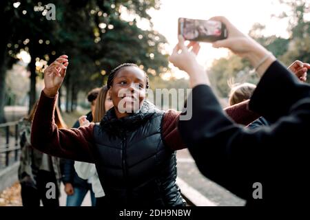 Cropped hands of woman filming teenage girl dancing on street in city Stock Photo