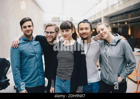 Group portrait of confident male and female computer programmers standing together in office Stock Photo