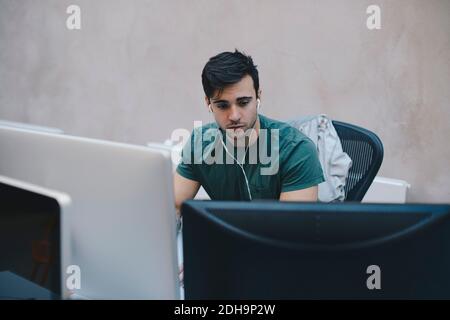 Male computer programmer using desktop PC in office Stock Photo