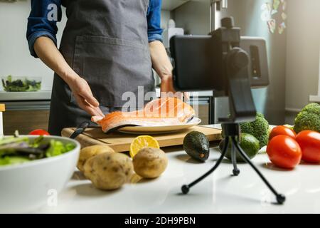 online food courses - woman vloger recording video at home kitchen Stock Photo