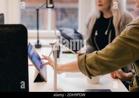 Business colleagues discussing over wind power on digital tablet at office desk Stock Photo