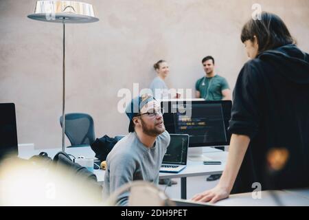 Male and female computer programmers discussing in creative office Stock Photo