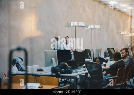 Male and female computer programmers discussing in creative office Stock Photo