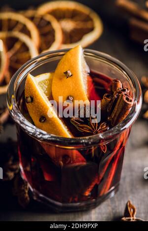 Mulled red wine with oranges and different spices in glass on the rustic background. Christmas food. Winter decorations. Selective focus. Shallow dept Stock Photo