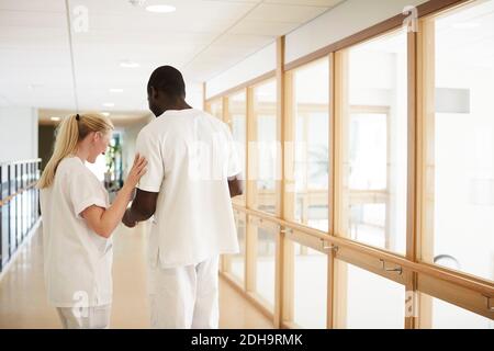 Male and female nurse standing at hospital corridor Stock Photo