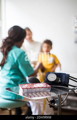Rear view of pediatrician with boy and mother in clinic Stock Photo