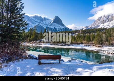 Natural scenery in early winter season sunny day morning. Drift ice floating on Bow River. Clear blue sky, snow capped Mount Lawrence Grassi Stock Photo