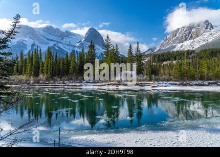 Natural scenery in early winter season sunny day morning. Drift ice floating on Bow River. Clear blue sky, snow capped Mount Lawrence Grassi Stock Photo