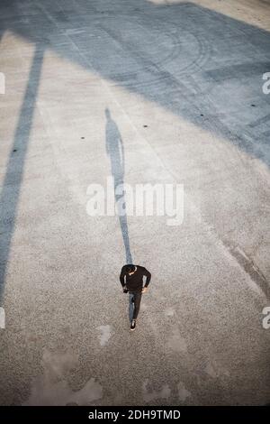 High angle view of man using smart phone while walking on footpath Stock Photo
