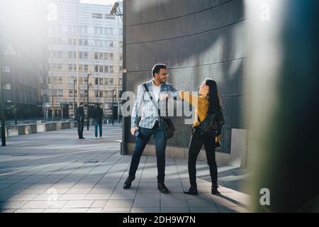 Man and woman greeting with elbows Stock Photo