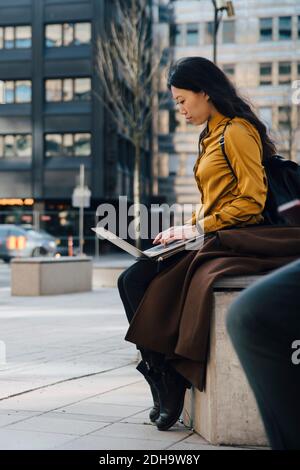 Woman working outside using laptop Stock Photo