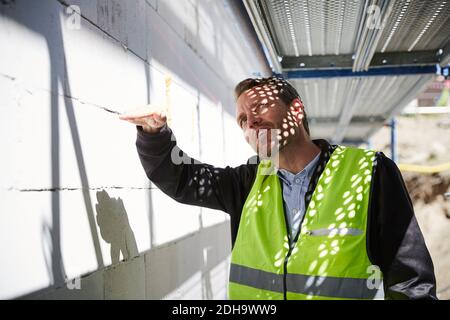 Architect gesturing while analyzing at construction site Stock Photo
