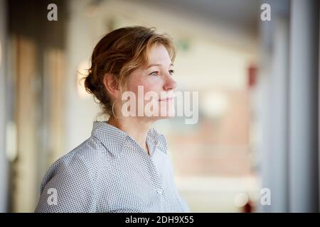 Confident female entrepreneur looking away while standing at workplace Stock Photo