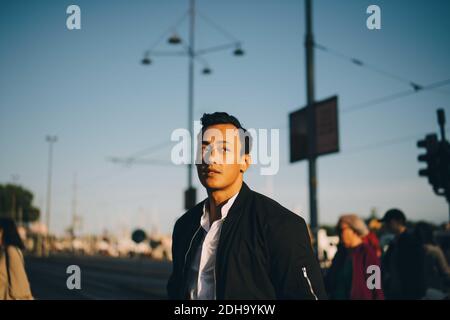 Contemplating young man looking away in city Stock Photo