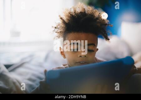 Close-up of boy using digital tablet on bed at home Stock Photo