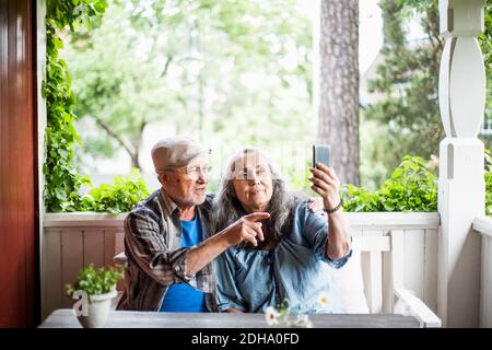 Senior couple taking selfie in porch Stock Photo