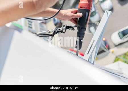 Installing the outdoor unit of the air conditioner, using drill fixing the unit holders Stock Photo
