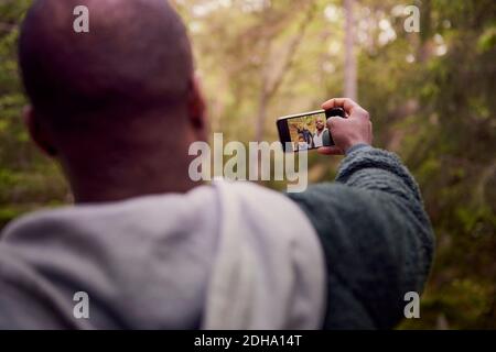 Man taking selfie with family in forest Stock Photo