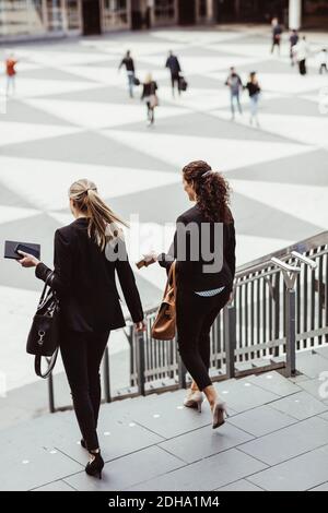 Businesswomen moving down staircase Stock Photo