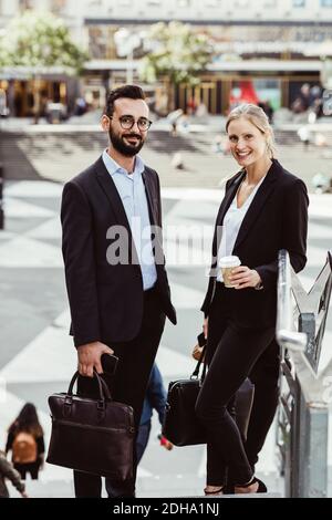 Portrait of smiling male and female professionals standing on staircase Stock Photo