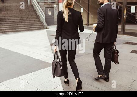 Rear view of business people walking and talking outdoors Stock Photo