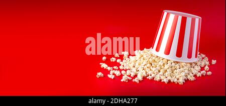 Striped box with popcorn on red background Stock Photo