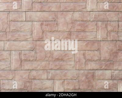 Beige pink wall with decorative masonry of relief rectangular tiles. Background texture. Full screen Stock Photo