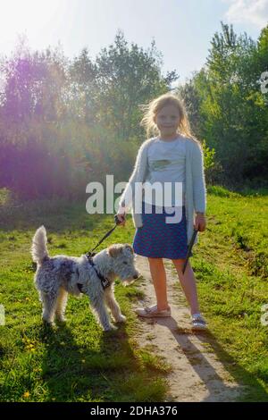 Portrait of a smiling girl standing with her dog Stock Photo
