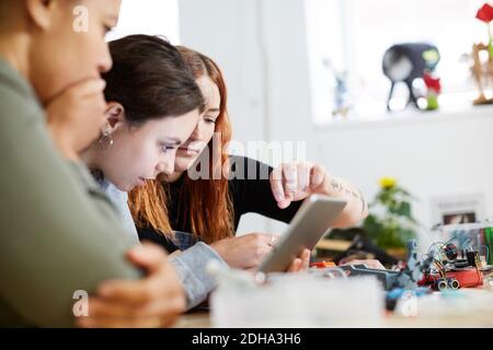 Multi-ethnic female engineers using digital tablet at table in workshop Stock Photo