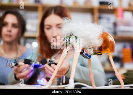 Young female inventors making robot model at workshop Stock Photo