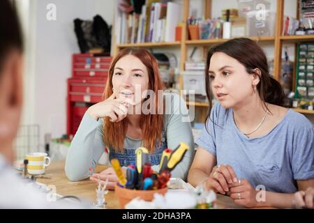 Female technicians sitting at table in workshop Stock Photo