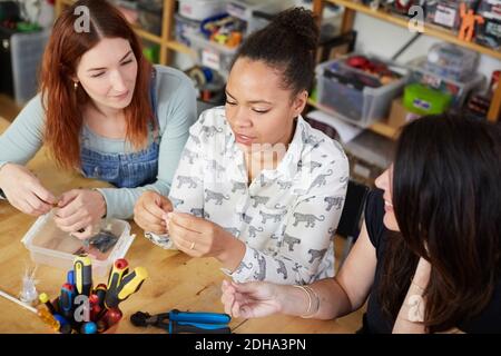 High angle view of female technicians sitting at table in workshop Stock Photo