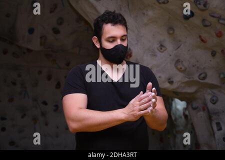 Man smearing his hands with magnesium powder getting ready to climb. Climbing at a climbing wall. Stock Photo