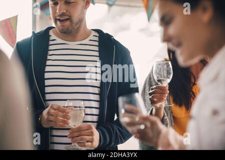 Young friends enjoying party with wine at home Stock Photo