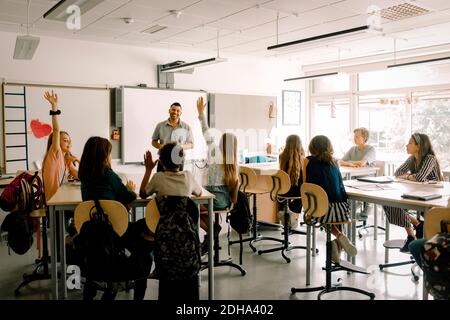 Male and female students with teacher in classroom Stock Photo
