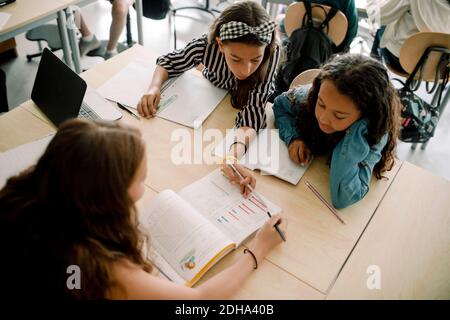High angle view of female students studying from book in classroom Stock Photo