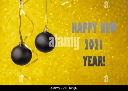 Two gray christmas balls on golden bokeh background. Minimal winter composition. New Year concept, copy space. Toned in color of the year Stock Photo