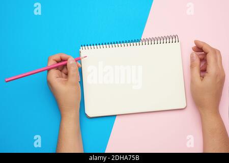 Two female hands holding open notepad with clean sheets Stock Photo